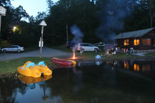 Paddle boat, kayaks, and campfire outside of Cabin number 1 (Bay Cabin)